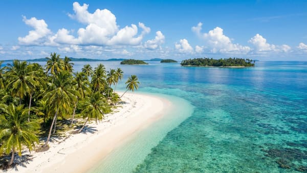 Neobydlený tropický ostrov souostroví Banyak s bílou pláží a palmami