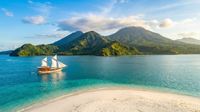 Panoramatický pohled na pobřeží Sulawesi s tradiční lodí Phinisi
