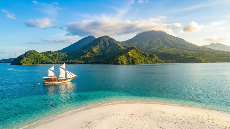 Panoramatický pohled na pobřeží Sulawesi s tradiční lodí Phinisi